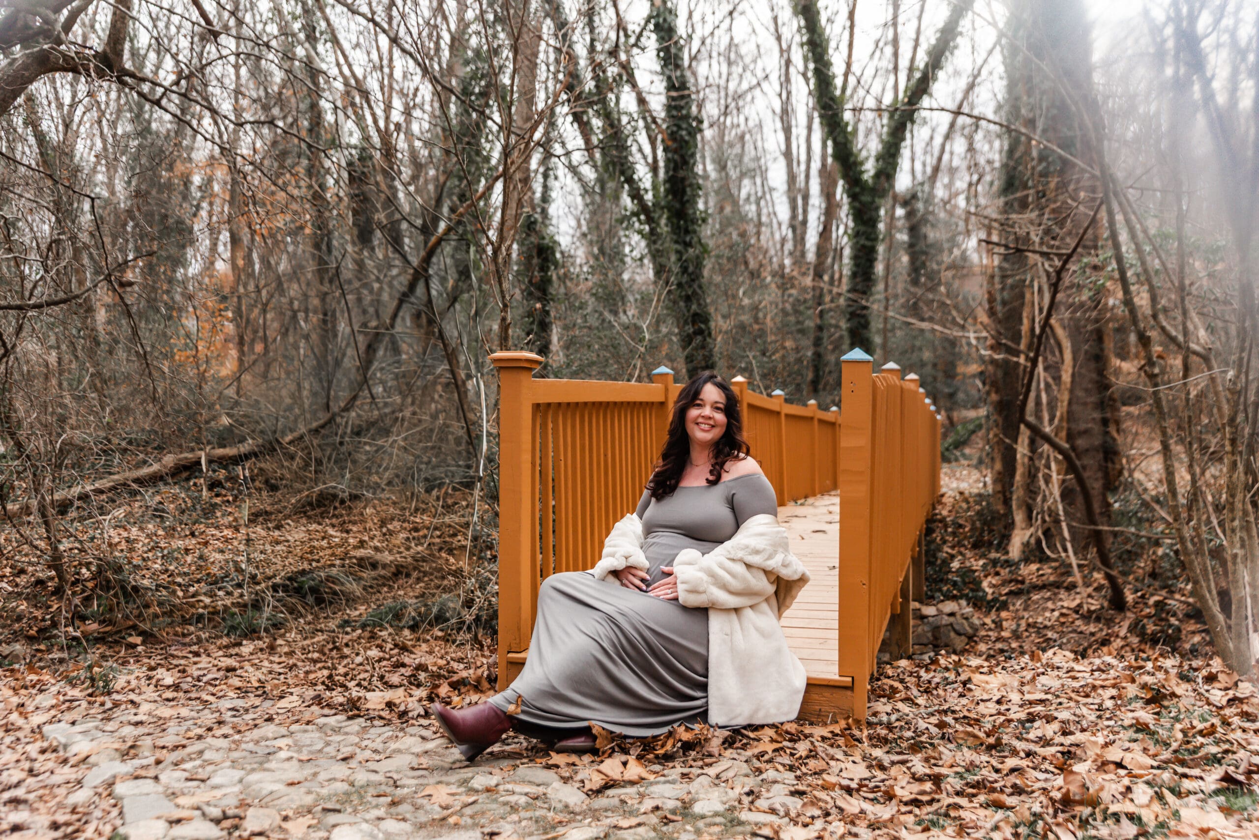 maternity session pony pasture richmond va winter. expecting mother sitting on a bridge.
